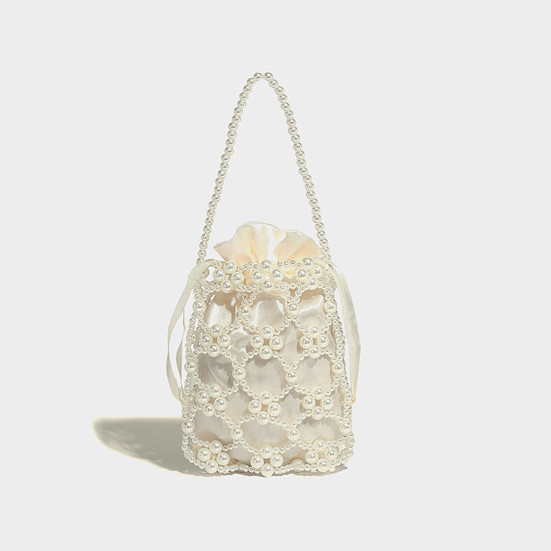 Small pearl-beaded lattice drawstring bucket bag with beaded shoulder strap and ribbon closure, detail view 6