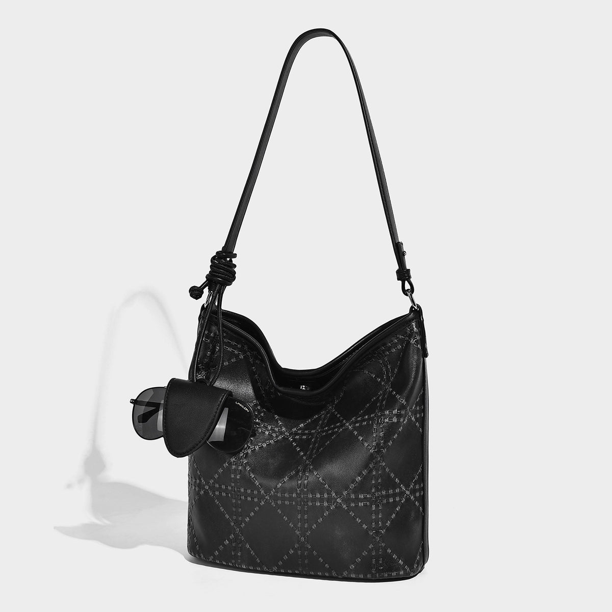 Diamond-quilted leather-look bucket shoulder bag with knotted strap accent and attached mini pouch, front view
