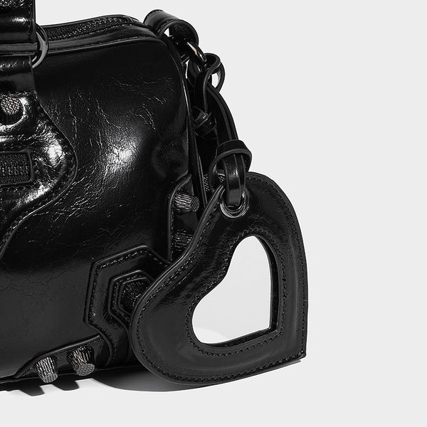 Glossy studded mini satchel bag with braided top handles, front zip pocket, heart charm, and detachable crossbody strap