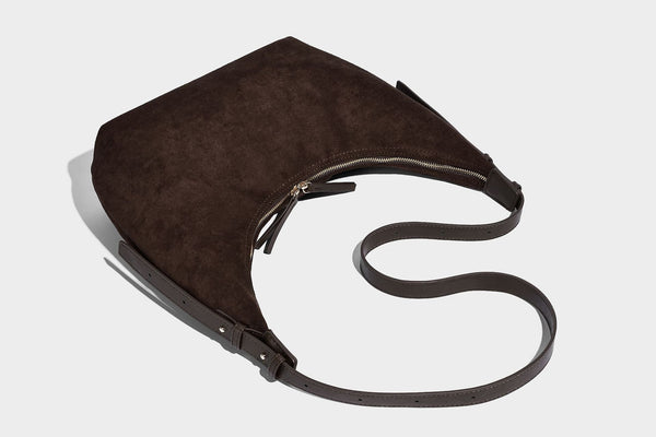 Slouchy crescent hobo shoulder bag in dark chocolate matte suede-look finish with adjustable strap and twin-pull top zip