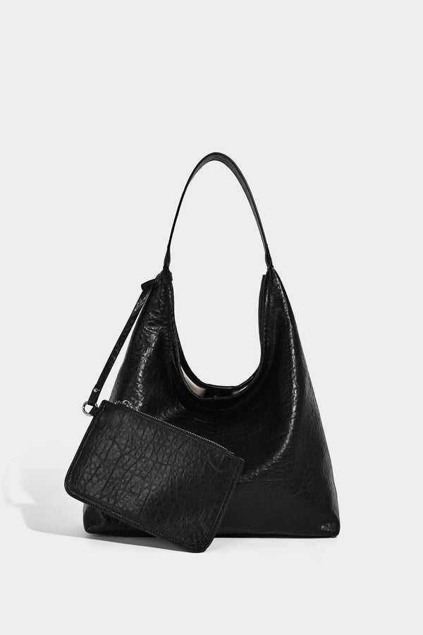 Slouchy hobo shoulder bag in pale yellow glossy pebbled leather-look finish with single shoulder strap and detachable front