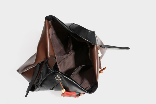 Two-tone black and brown leather-look slouchy shoulder bag with beaded tassel charm and silver-tone hardware, detail view 37