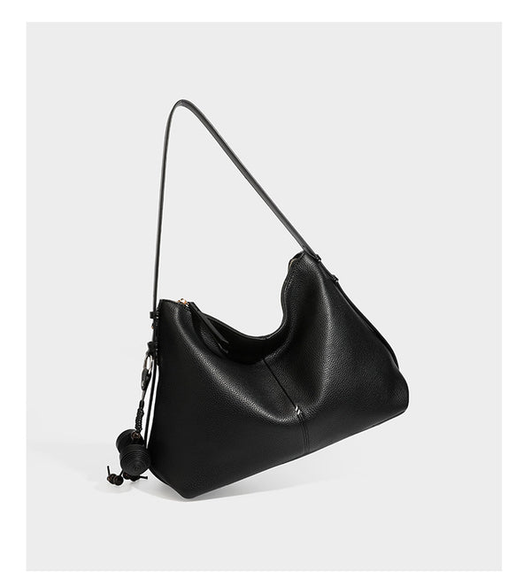 Slouchy hobo shoulder bag with pebbled leather-look finish, zip-top closure, gold-tone hardware, and hanging bead charm