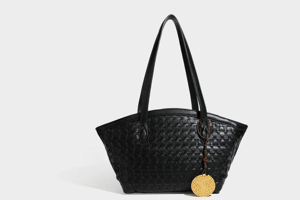 Large leather-look tote bag with geometric woven emboss, double shoulder straps, and round woven cord charm in brown, detail