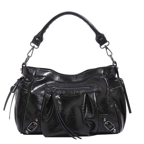 Slouchy glossy crinkle leather-look shoulder bag with silver stud accents, tassel ties, front zip pocket, and top handle