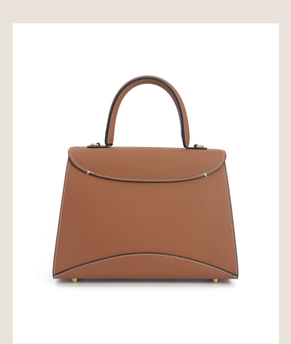 Structured trapezoid top-handle satchel in golden brown cross-grain textured finish with gold M-shaped clasp hardware and
