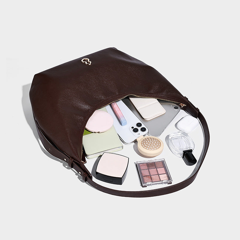 Weiche, sichelförmige Hobo-Schultertasche in dunkelbrauner glatter Lederoptik mit Logo-Anhänger in Goldoptik und verstellbarem Riemen