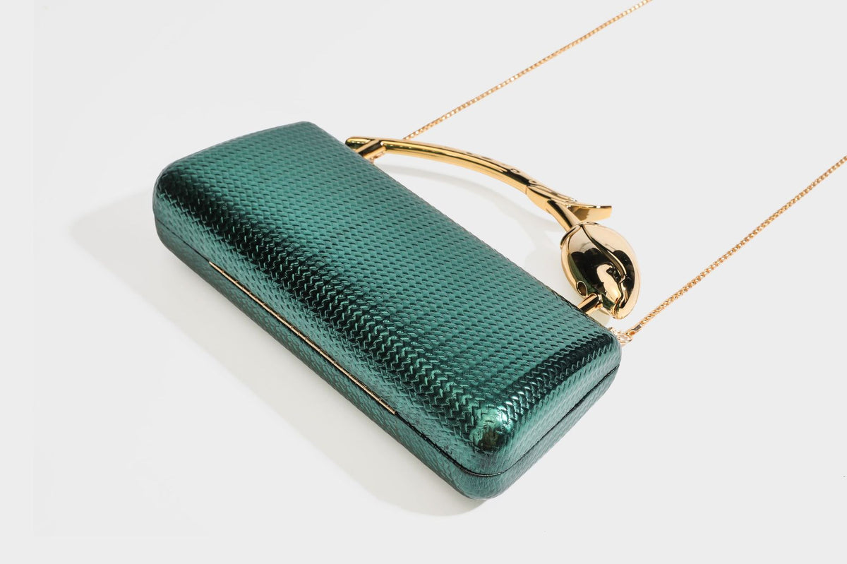Structured rectangular metallic woven clutch bag with sculptural gold-tone leaf top handle and detachable chain strap, detail
