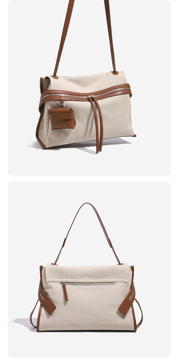 Cream canvas zip-top shoulder bag with cognac leather-look trim, dual zipper, attached mini pouch, and tassel strap ties