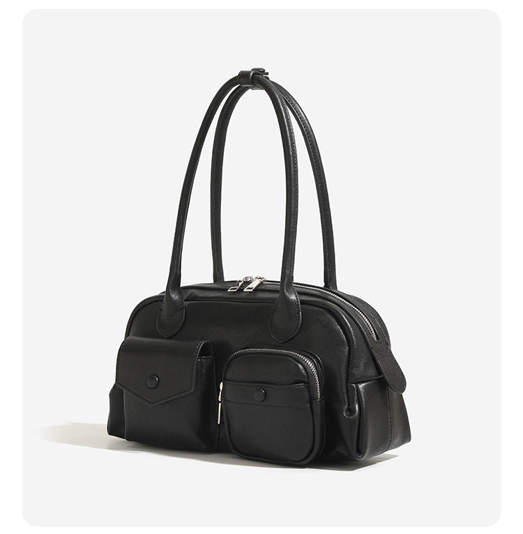 Structured retro bowling-style top-handle handbag with dual zip closure, front snap-flap pocket, and front zip pocket, detail