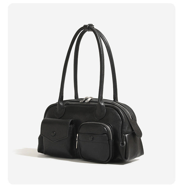 Structured retro bowling-style top-handle handbag with dual zip closure, front snap-flap pocket, and front zip pocket, detail