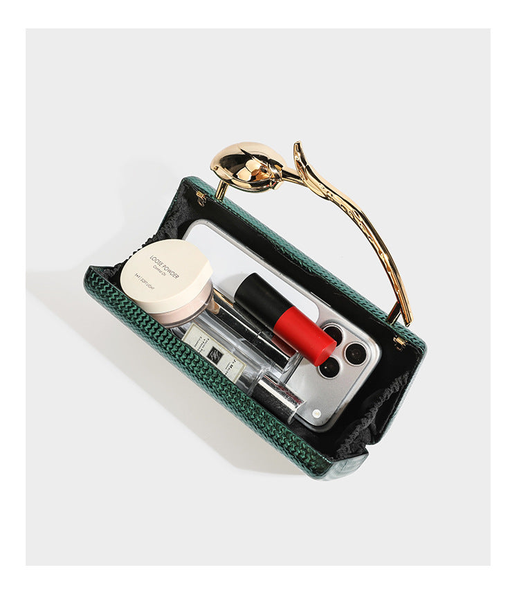 Structured rectangular metallic woven clutch bag with sculptural gold-tone leaf top handle and detachable chain strap, detail