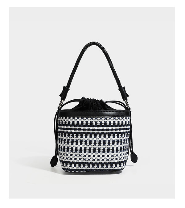 Small structured woven checker bucket bag with braided top handle, drawstring closure, and silver-tone hardware in black