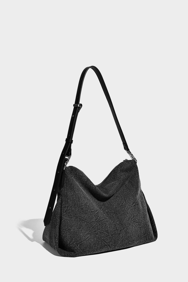 Charcoal denim-textured slouchy hobo bag with zip-top closure, silver-tone hardware, and adjustable leather-look crossbody