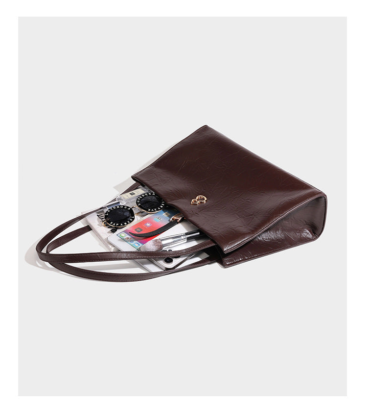 Strukturierte, rechteckige Tote-Schultertasche mit glänzender, geknautschter Lederoptik, langen Doppelriemen und goldfarbenem Emblem