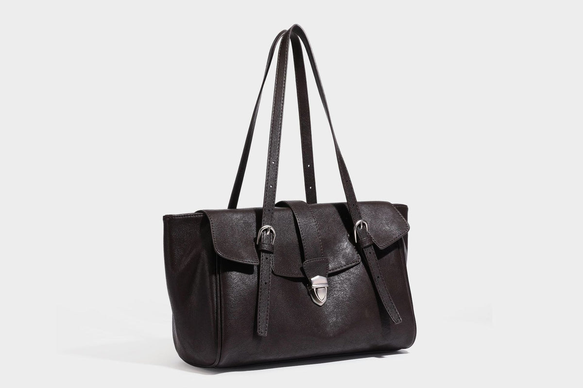 Large structured vintage-style tote bag with flap-front turn-lock closure, twin buckle straps, and double shoulder handles