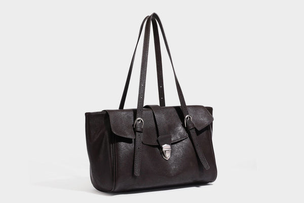 Large structured vintage-style tote bag with flap-front turn-lock closure, twin buckle straps, and double shoulder handles