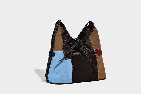 Patchwork bucket tote shoulder bag with tan, dark brown, olive, red, and sky blue color-block panels, white contrast, detail