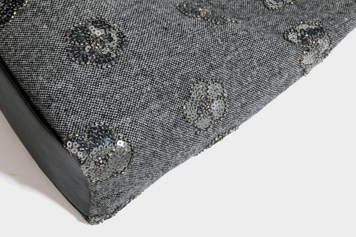 Lässig fallende, trapezförmige Schulter-Tote in Anthrazitgrau mit floralen Paillettenmotiven in Silber, Riemen in Lederoptik und herabhängendem Perlenbesatz