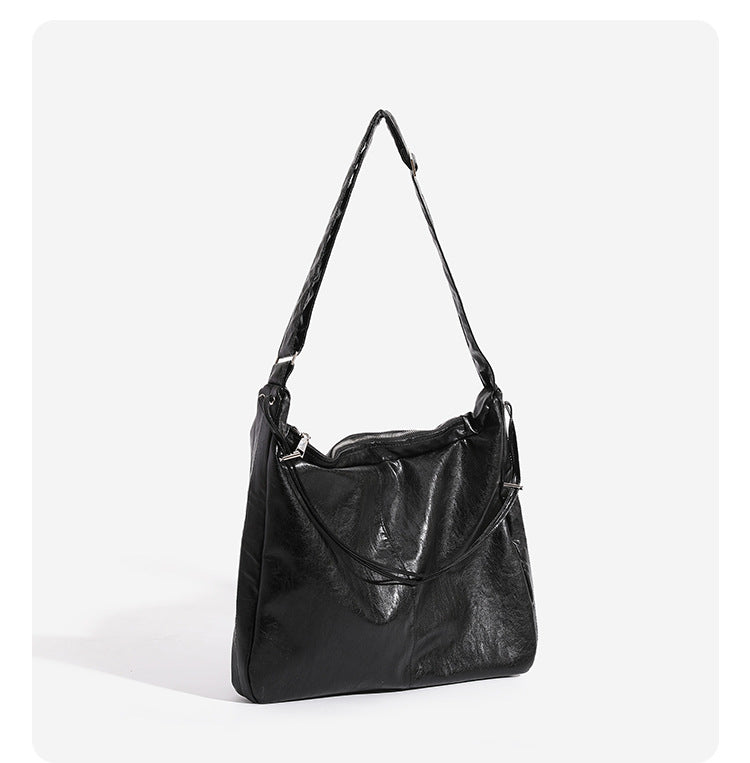 Oversized slouchy hobo shoulder bag with glossy crinkled leather-look finish, drawstring gathered sides, and silver-tone