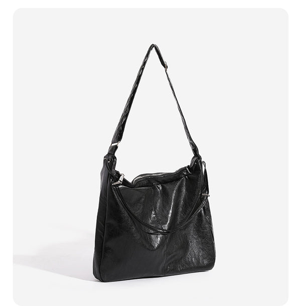 Oversized slouchy hobo shoulder bag with glossy crinkled leather-look finish, drawstring gathered sides, and silver-tone
