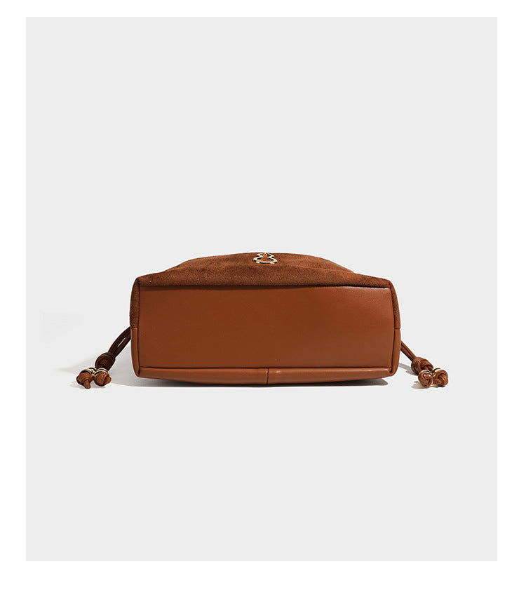 Suede-look drawstring shoulder bag in brown with smooth trim, knotted bead drawstring closure, slim adjustable strap, and