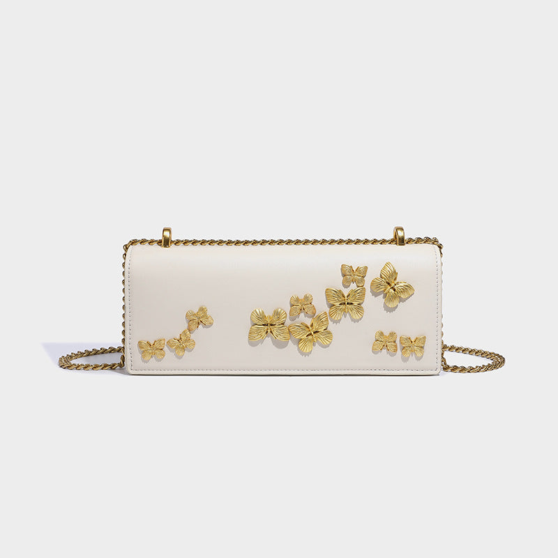 Slim rectangular crossbody bag with gold-tone butterfly metal appliqués and fine antiqued chain strap, detail view 3