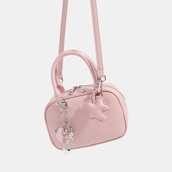 Small structured rounded-rectangle mini handbag with glossy leather-look finish, top zip closure, silver-tone hardware, and