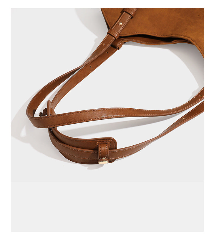 Oversized suede-finish tote shoulder bag in caramel brown with slim leather-look straps and gold-tone logo hardware, detail