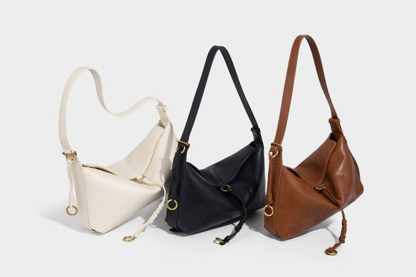 Slouchy brown leather-look shoulder bag with knotted drawcord tie closure, gold-tone ring hardware, and long adjustable