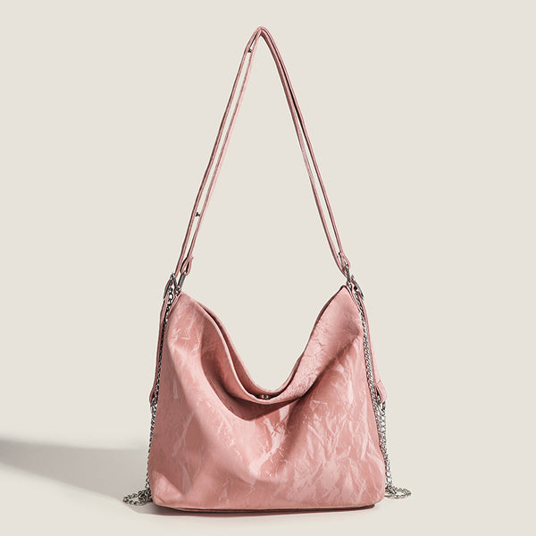 Blush pink slouchy hobo bag with crinkled sheen finish, silver-tone chain hardware, and adjustable shoulder strap, detail