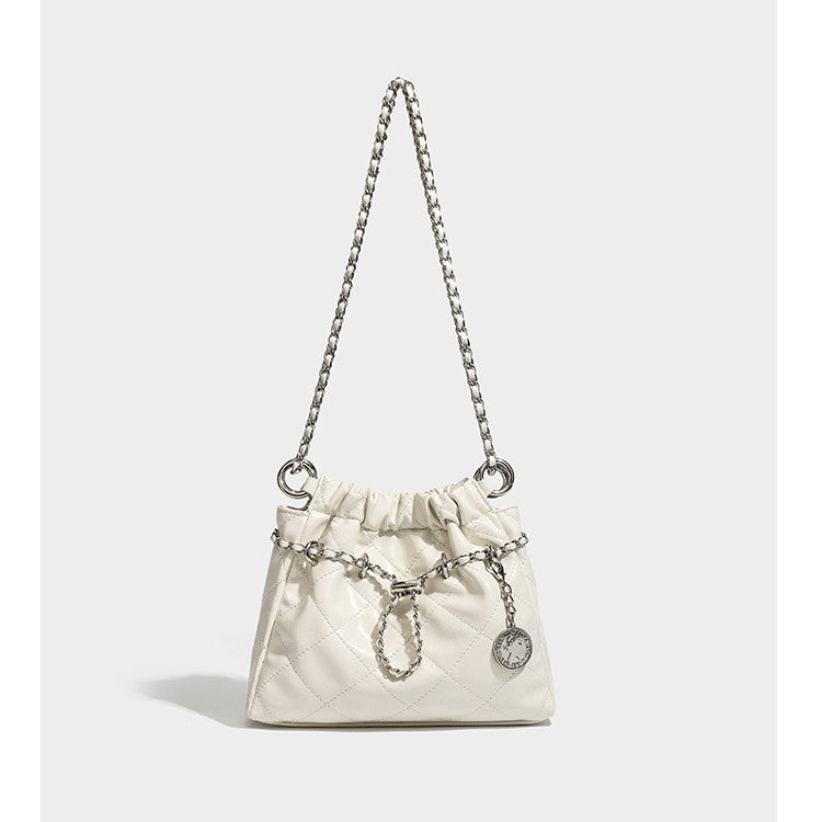 Glossy diamond-quilted drawstring bucket bag with silver chain shoulder strap and medallion charm, detail view 4