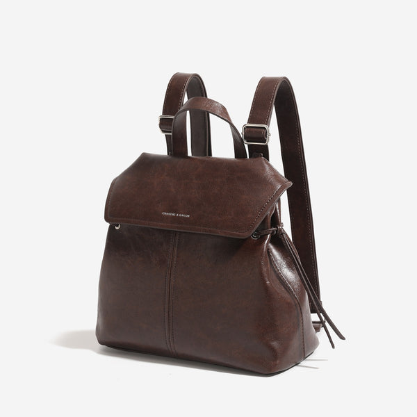 Strukturierte Rucksacktasche mit Überschlag in Used-Lederoptik, seitlichen Kordelzügen und silberfarbenen Beschlägen, Detailansicht