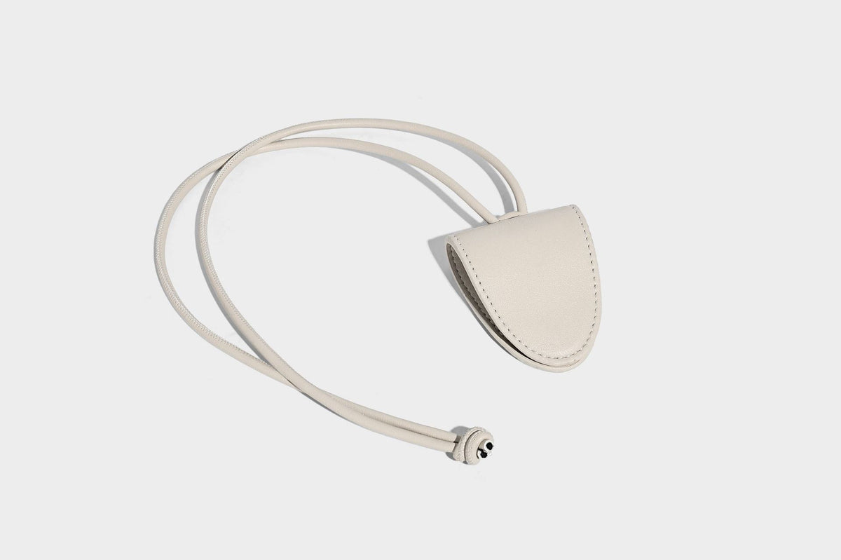 Small embossed half-moon shoulder bag with top zipper, detachable front pouch, and adjustable slim strap, detail view 25