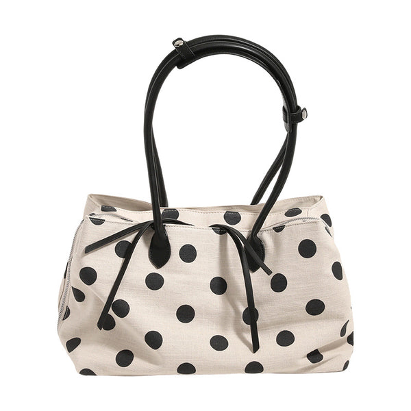 Cream canvas tote bag with black polka dots, rounded leather-look handles, and zip-top closure, detail view 5