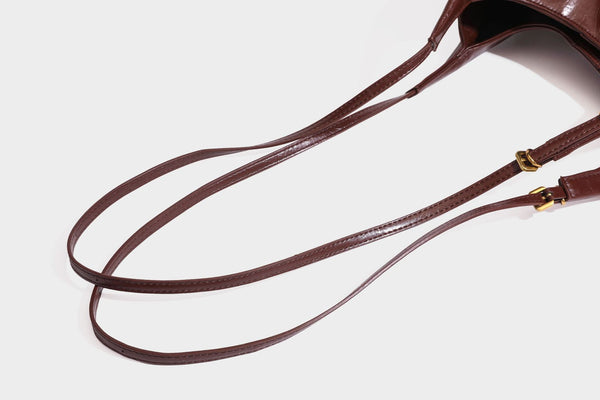 Locker fallende Hobo-Schultertasche mit offenem Oberteil aus glänzendem, geknautschtem Lederimitat in Dunkelbraun, mit schmalem verstellbarem Riemen und goldfarbenem