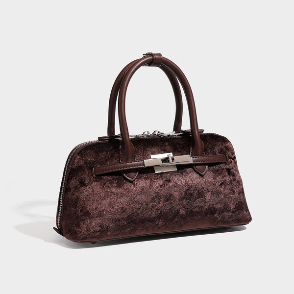 Small structured satchel bag in dark brown velvet-like textured finish with leather-look trim, silver-tone turn-lock bar