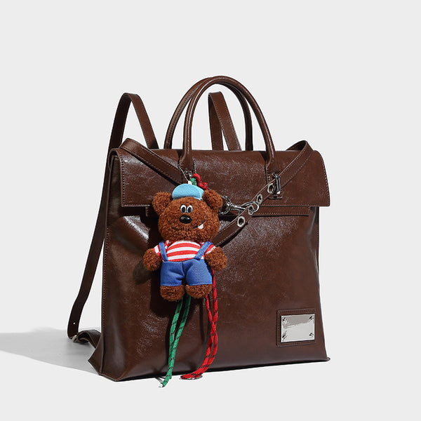 Großer glänzender Rucksack-Shopper aus Lederoptik mit Plüschbären-Anhänger und silberfarbenen Beschlägen, Vorderansicht
