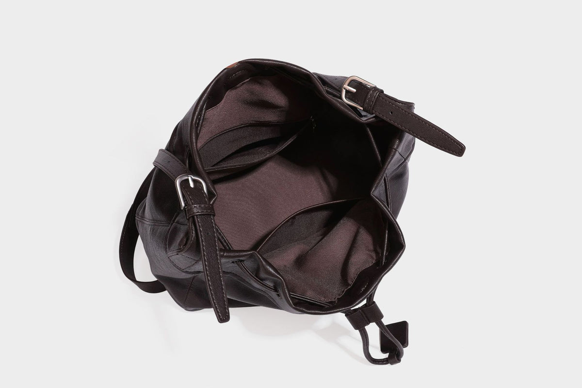 Lässig fallende Beuteltasche mit Kordelzug in dunkler Espresso-Lederoptik, verstellbarem Riemen und Ringbeschlägen aus Metall