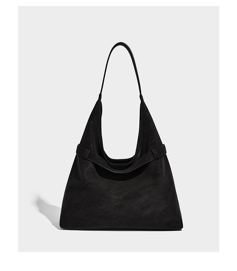 Slouchy oversized shoulder tote bag with matte textured finish, wrap-around buckle strap, and detachable front zip pouch