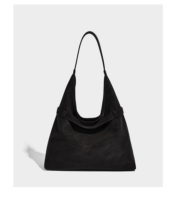 Slouchy oversized shoulder tote bag with matte textured finish, wrap-around buckle strap, and detachable front zip pouch