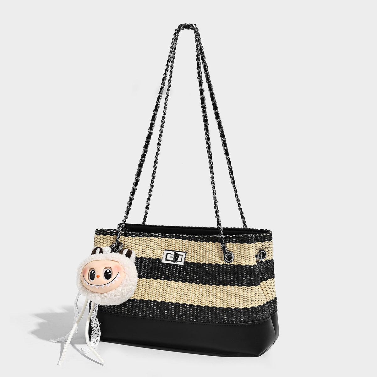 Structured black and beige striped woven shoulder bag with silver chain strap and turn-lock metal clasp, front view