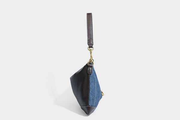 Slouchy denim shoulder bag with dark leather-look trim, gold-tone chain-link hardware, and top zipper closure, detail view 28