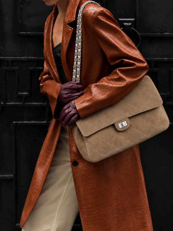 Quilted diamond-stitch flap shoulder bag with double silver chain strap and turn-lock closure in suede-look finish, detail
