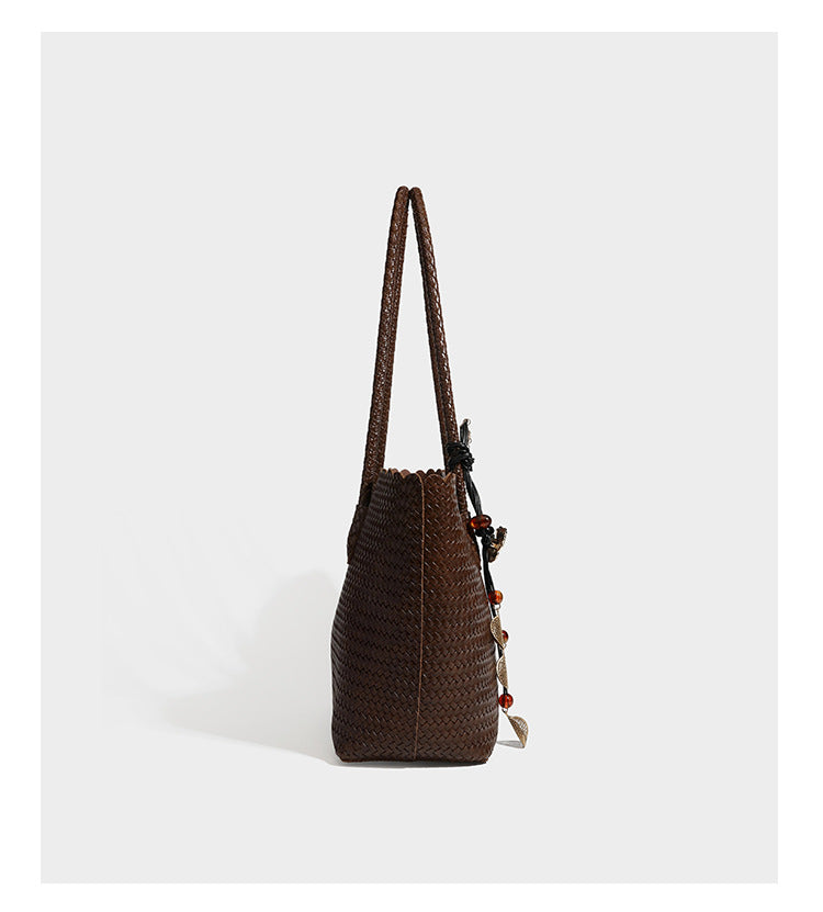 Large open-top woven leather-look tote bag in dark brown with scalloped edge, braided double shoulder straps, and decorative