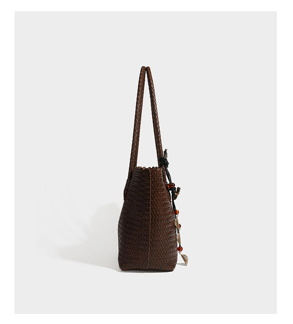 Large open-top woven leather-look tote bag in dark brown with scalloped edge, braided double shoulder straps, and decorative