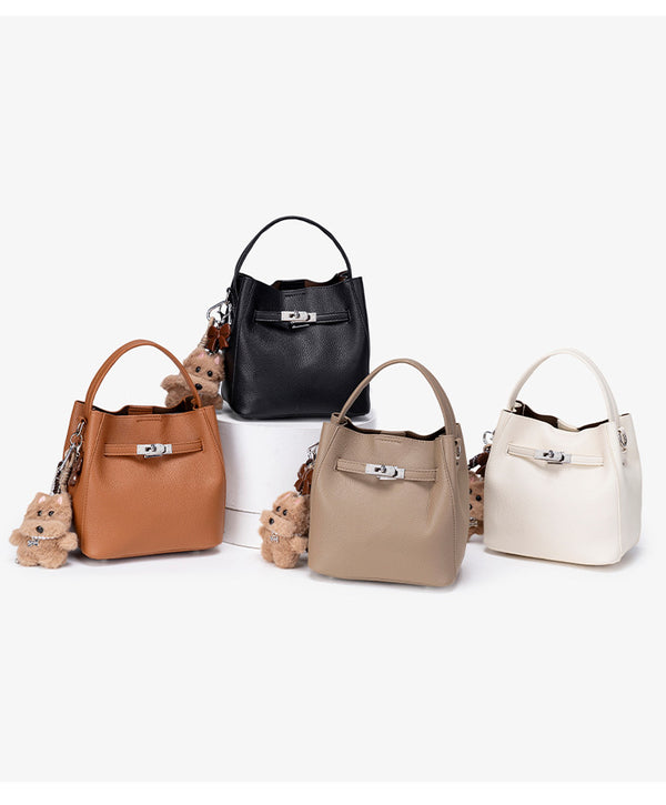 Compact structured bucket bag in pebbled leather-look finish with silver turn-lock front clasp, dual top handles, detachable