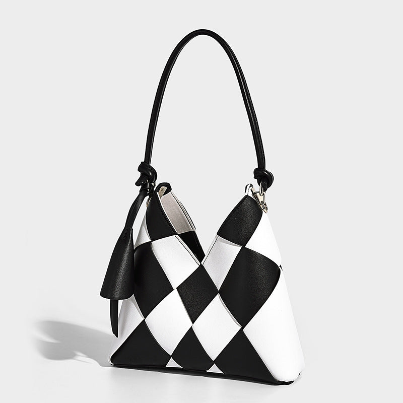 Compact bucket shoulder bag with black-and-white diamond patchwork panels, knotted top handle, gold-tone hardware, and, front