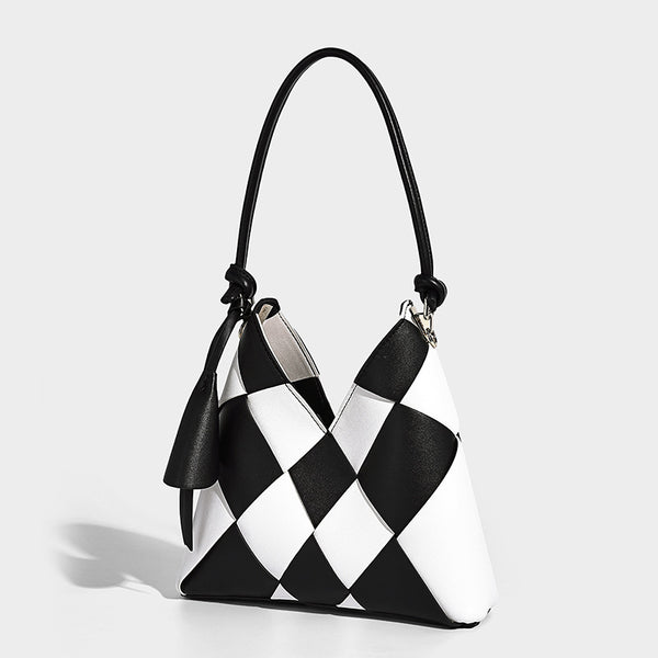 Compact bucket shoulder bag with black-and-white diamond patchwork panels, knotted top handle, gold-tone hardware, and, front