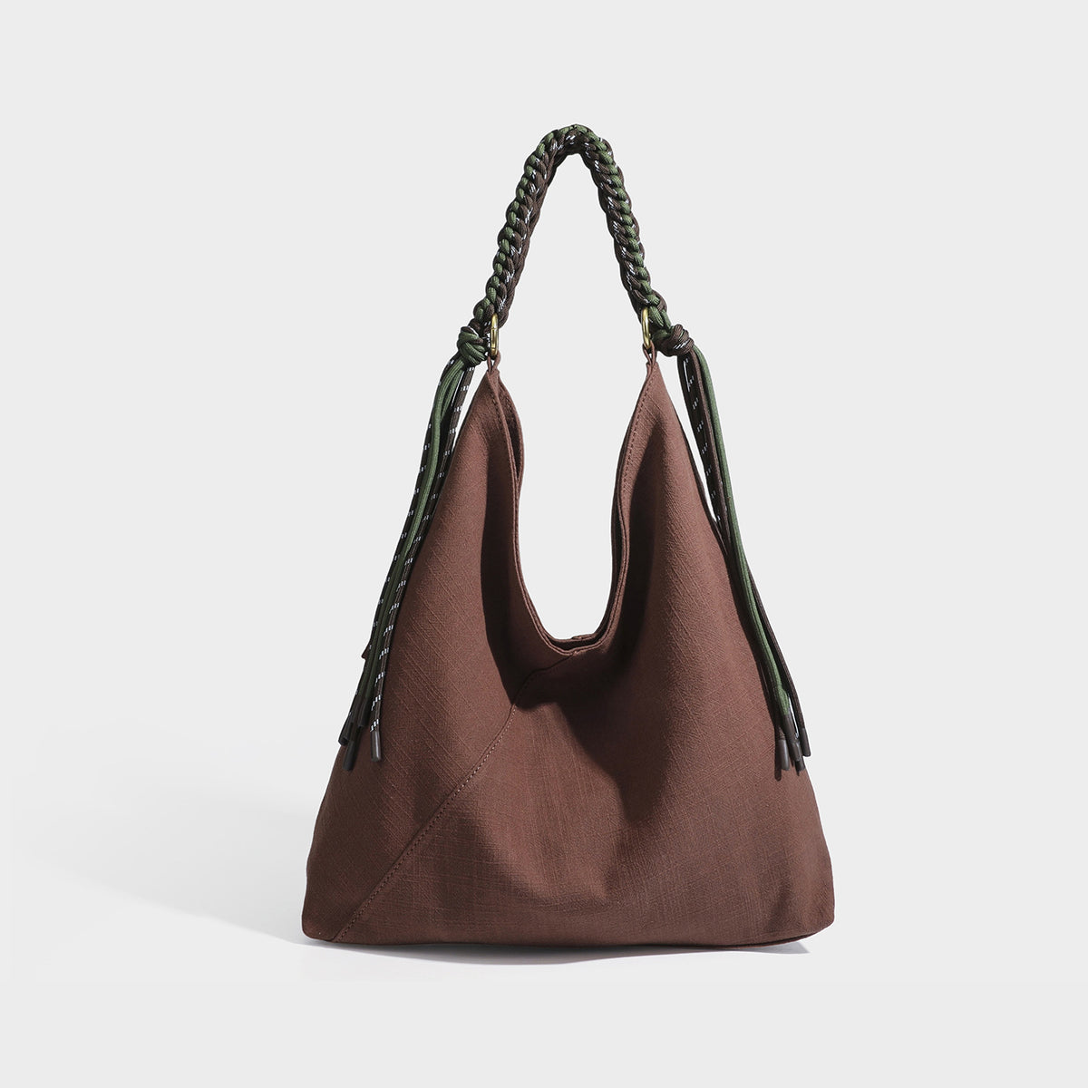 Soft slouchy cream canvas shoulder tote with braided brown and green cord handle, gold-tone ring hardware, and tassel trim